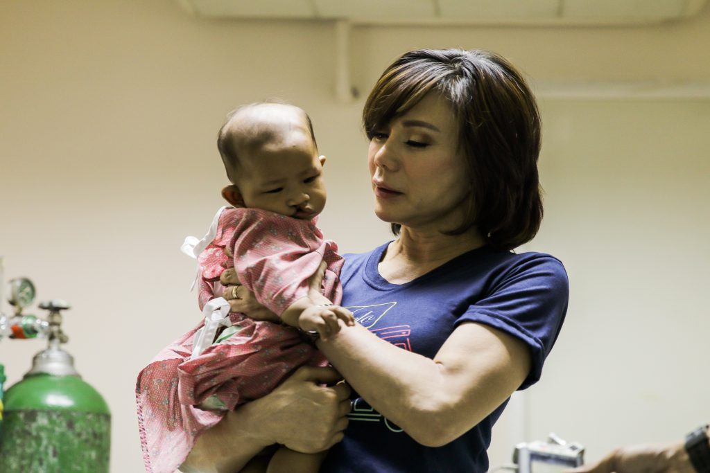 Dr. Vicki Belo carrying a baby with cleft condition